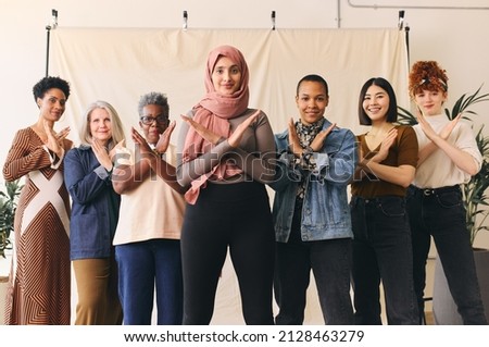 Middle Eastern woman wearing hajib gesturing Break The Bias in support of International Women's Day with female friends Royalty-Free Stock Photo #2128463279