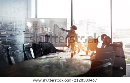 Their company is taking the city by storm. Multiple exposure shot of businesspeople in a meeting superimposed on a cityscape. Royalty-Free Stock Photo #2128500467