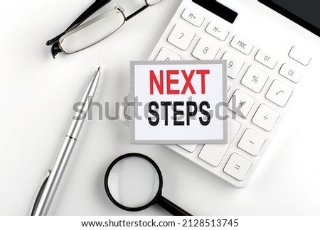 NEXT STEPS text on sticker with calculator, glasses and magnifier