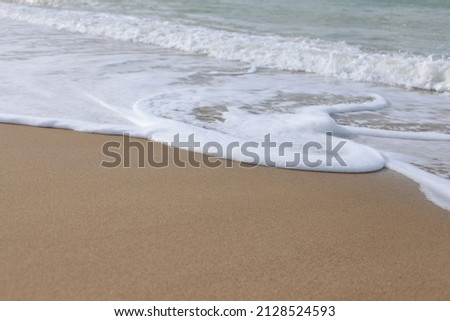Beautiful waves foam and roll onto the shore. Marine picture, sea sandy beach. Foam on the sand.
Desktop design. Wallpaper design for website