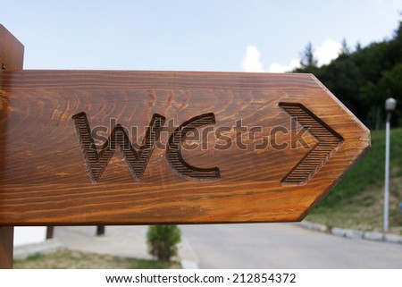 Sign of public toilets WC on wooden plate