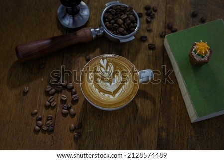 cup of coffee latte art in barista hand. 