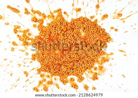 Spaghetti rings in tomato sauce splattered on a white background Royalty-Free Stock Photo #2128624979