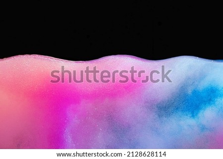 Pink bubbly boiling water against black background