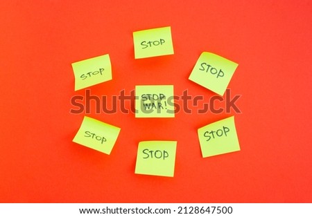 Stop war. Hand writing on yellow paper on a red background. Please stop the war 