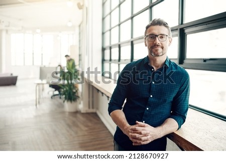 Stay hungry for success. Portrait of a confident mature businessman working in a modern office. Royalty-Free Stock Photo #2128670927