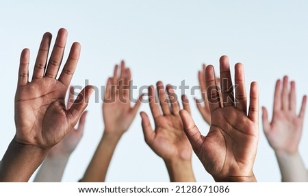 Raise your hands as one. Shot of a group of hands reaching up against a white background. Royalty-Free Stock Photo #2128671086