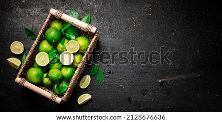Lime with leaves in a basket. On a black background. High quality photo