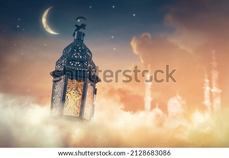 Ornamental Arabic lantern with burning candle glowing at night. Festive greeting card, invitation for Muslim holy month Ramadan Kareem. Royalty-Free Stock Photo #2128683086