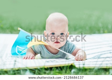 Cute baby 5 months old with flag of Ukraine close-up.