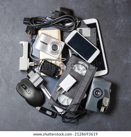 Old electronic devices on a dark background. The concept of recycling and disposal of electronic waste. Royalty-Free Stock Photo #2128693619