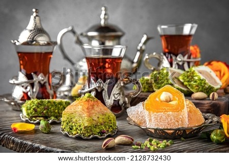 Oriental sweets. Lukum, pistachio baklava. Fragrant tea. Turkish mood still life. For advertising, window dressing, travel posters and cafes. Royalty-Free Stock Photo #2128732430