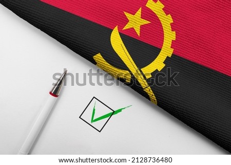 Pencil, Flag of Angola and check mark on paper sheet 