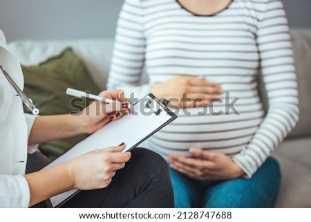 Shot of an confident female doctor consulting with a pregnant patient at a hospital during the day. Gynecologist talking with young female patient during medical consultation