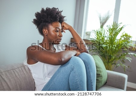 Unhappy lonely depressed woman at home, she is sitting on the couch and hiding her face on a pillow, depression concept. Psychology, solitude and people Royalty-Free Stock Photo #2128747706