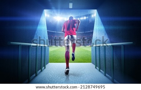 Running football player and stadium, 3d rendering. Royalty-Free Stock Photo #2128749695