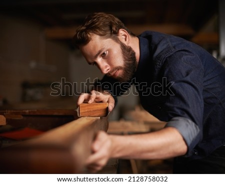 Since opportunity didnt knock, he decided to build a door. Shot of a young artisan working intently in his workshop. Royalty-Free Stock Photo #2128758032