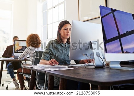 Technology ensures their workday is a productive one. Shot of colleagues working on their computers in an open plan office. Royalty-Free Stock Photo #2128758095