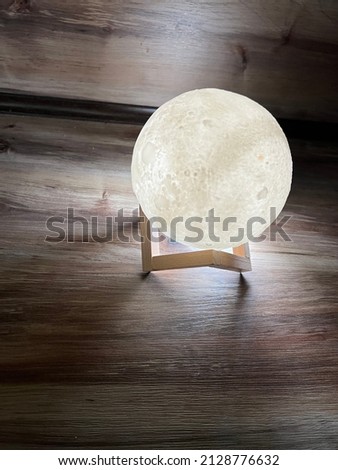 glowing cold moon on a stand on a wooden table top