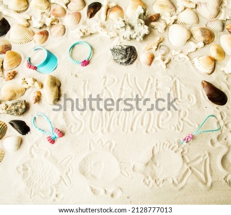 Flat lay.  The inscription on the sand summer, travel, children's drawings of fish and toys.  Seashells, pebbles and corals.  Concept vacation, travel, summer.  Close-up background picture.