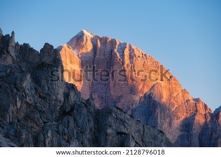 High cliffs during sunset. Dolomite Alps, Italy. Mountains and clear skies. View of mountains and cliffs. Natural mountain scenery. Photography as a backdrop for travel. Royalty-Free Stock Photo #2128796018