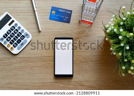 Top table of mobile phone mockup and credit card and calculator on wooden surface. Concept for money spending and financial background