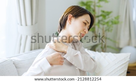 Asian woman with shoulder pain Royalty-Free Stock Photo #2128812254