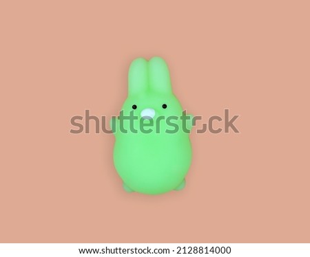 Antistress toy .Squishy .cute green bunny on pink background .summer concept .squeezable, soft, squeezable items to relieve stress, problems, worries, worries.