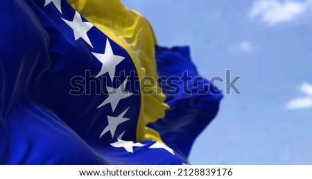 Detail of the national flag of Bosnia and Herzegovina waving in the wind on a clear day. Democracy and politics. Selective focus. Bosnia, is a country at the crossroads of south and southeast Europe Royalty-Free Stock Photo #2128839176