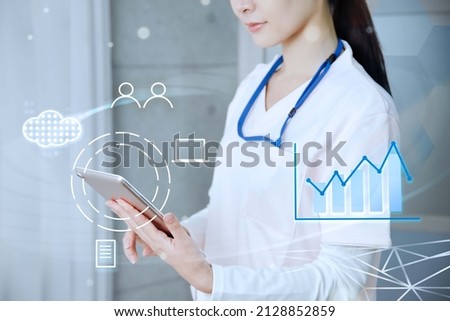 Asian female medical worker operating a tablet Royalty-Free Stock Photo #2128852859