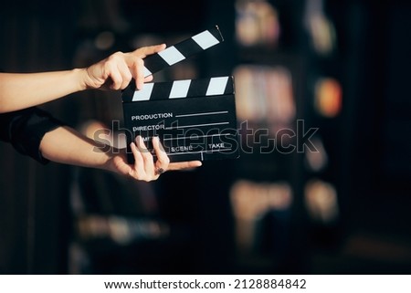 Hands Holding a Film Slate Directing a Movie Scene. Cinematography film-making conceptual image in between takes Royalty-Free Stock Photo #2128884842