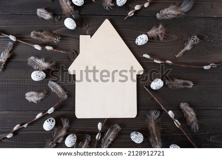 Easter frame with eggs and feathers on a dark wooden background. The minimal concept. Top view. Card with a copy of the place for the text.