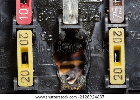 Burnt out car fuse box. Defective fuse block. Close-up photo. Royalty-Free Stock Photo #2128924637