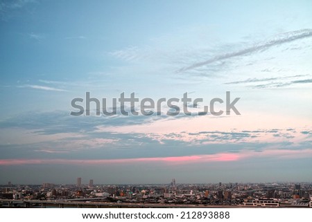 Tokyo skyline under blue sky with flowing clouds