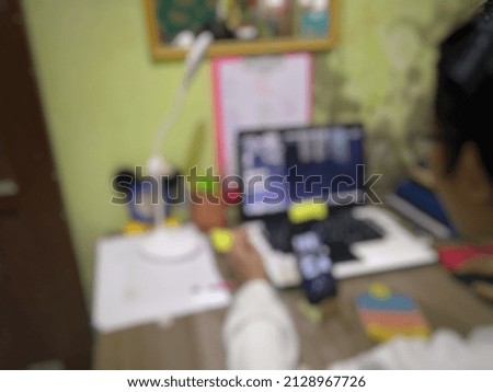 Defocused blured photo A child playing on a laptop, background.