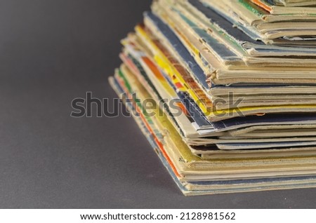 Collection of old comics and magazines against a gray background. Lots of old shabby print editions from the last century. The concept of collecting. Selective focus. No people.