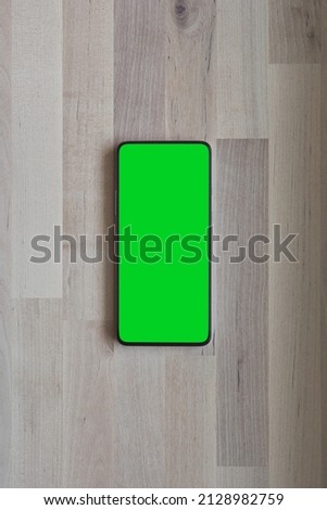 Mobile phone with round edges, with blank green screen for Infographic Global Business, isolated. 