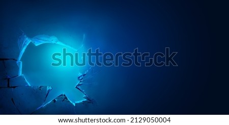 Broken glass hole in a blue neon light background