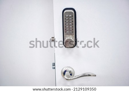 Digital door lock with metal handle. Door safety system, code keypad closeup. Open door with control system using digital locking and password to acces Royalty-Free Stock Photo #2129109350