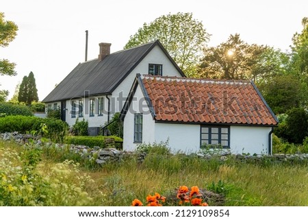 Picture of beautiful garden with apple trees, flowers and scandinavian style summer house