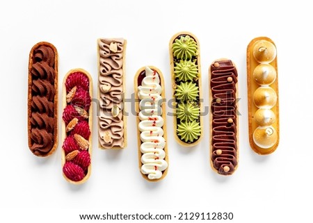 Top view of sweet bakery eclairs with color topping Royalty-Free Stock Photo #2129112830