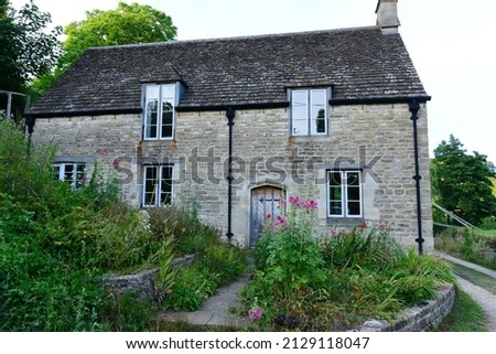 View of a Traditional Old Stone House on a Country Road in Rural England Royalty-Free Stock Photo #2129118047