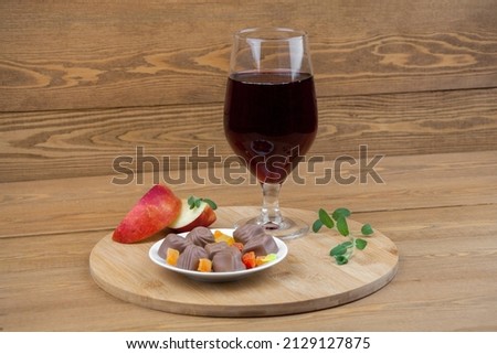 A glass of red wine. Chocolates. Red sliced apple. valentine's day. on a white saucer. the concept of new year and Christmas. on a white background. The concept of love. A glass goblet.