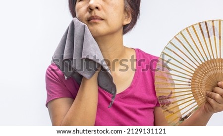 Middle aged woman feel hot flashes or overheated , symptoms of menopause Royalty-Free Stock Photo #2129131121