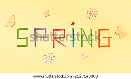 Spring letters on bright yellow background decorated with butterfly, flowers, ladybug, colorful letter. Spring is coming, minimal  flat lay concept.