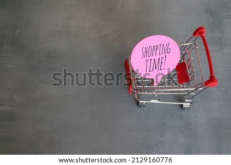 Red speech bubble with text SHOPPING TIME! inside shopping trolley. Copy space for text