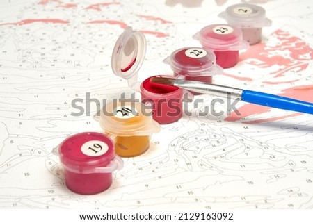 A set of paints, brushes and canvas for painting by numbers. Hobbies and leisure. Drawing at home