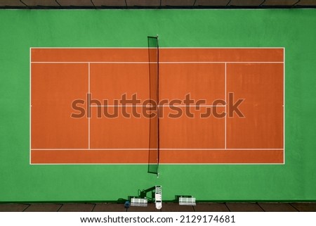 Aerial view of orange and green tennis hard court.