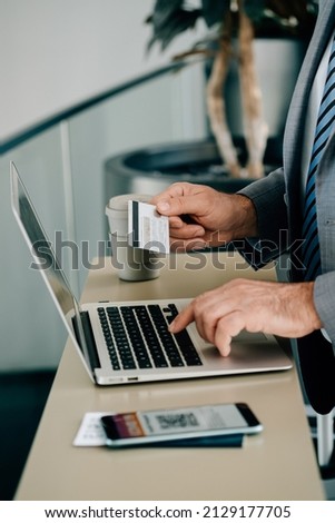 Close Up Photo of Man Hands Using Laptop Computer and Credit Card for Making Online Reservation or to Pay Taxes or Fee while Waiting at the Airport Royalty-Free Stock Photo #2129177705