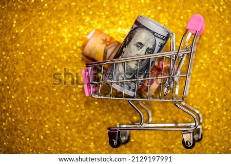 Small shopping cart with dollar and euro banknote for design purpose